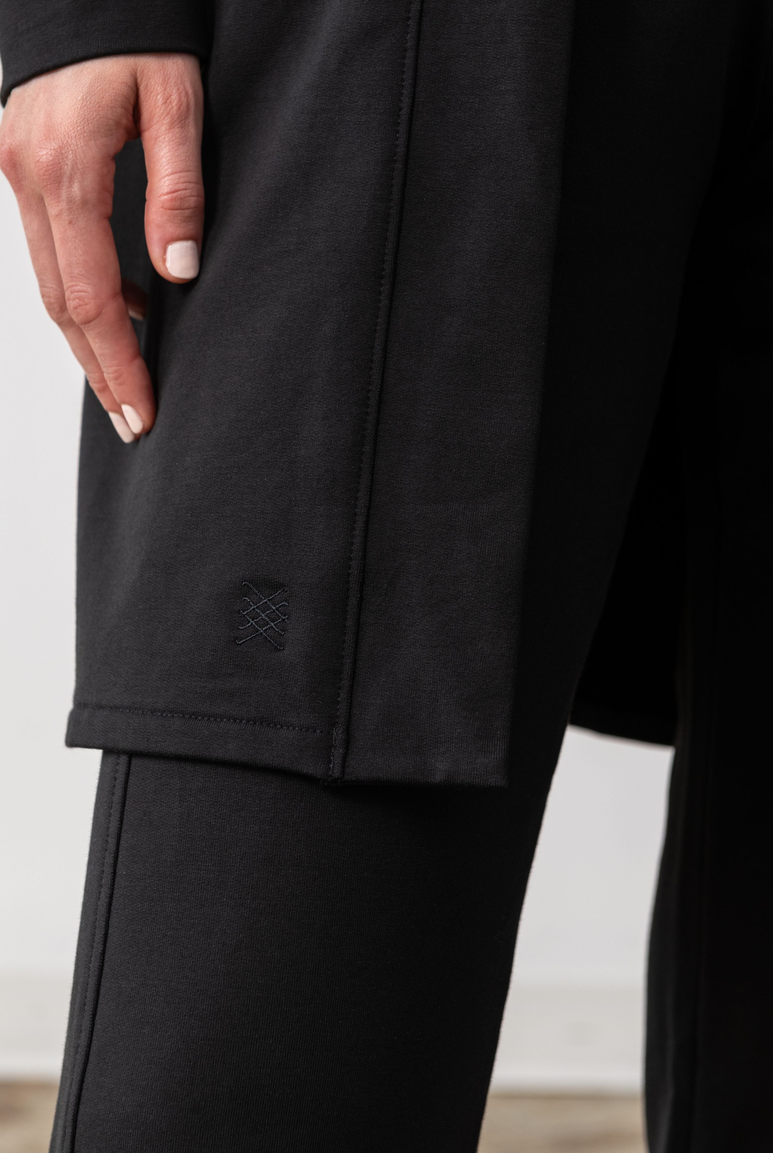 Zestt logo shown on Black cardigan